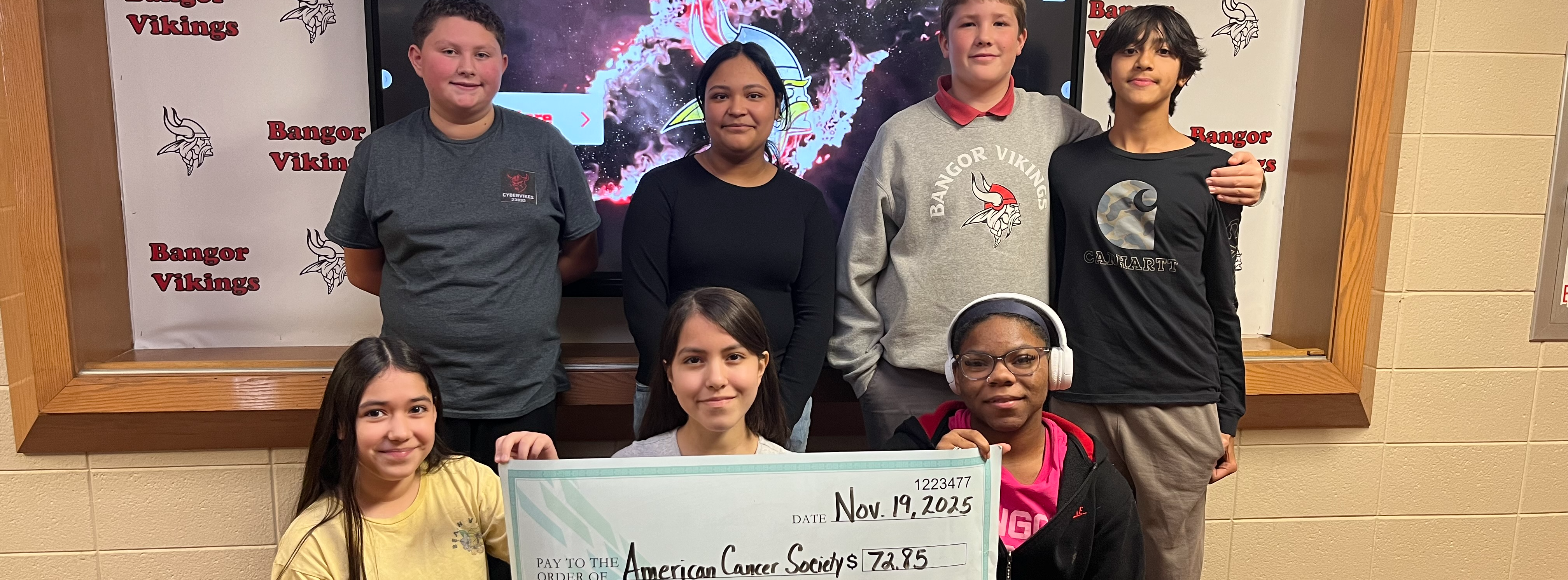 Student council group hold a large check.
