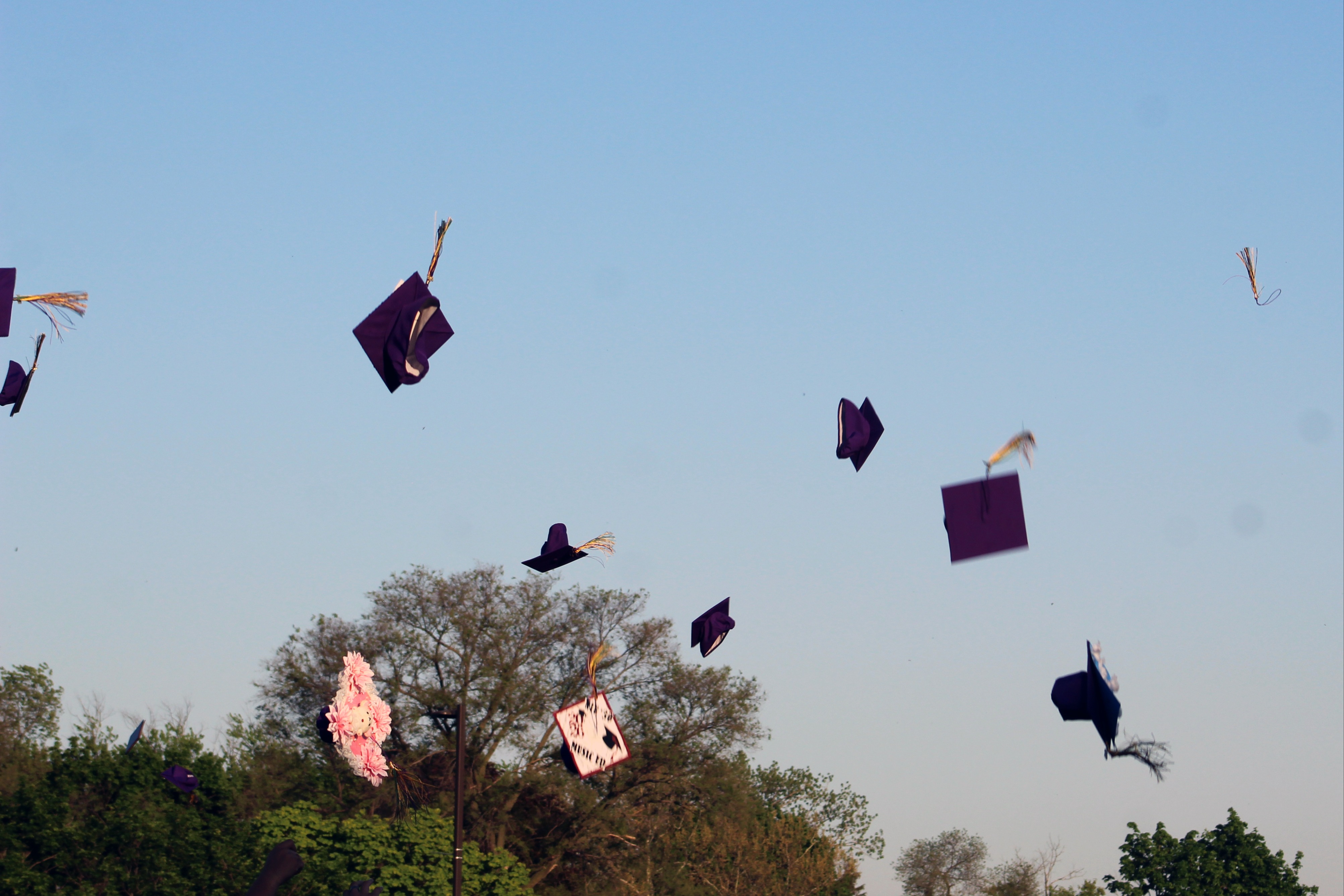 Graduation caps thrown high into the air by students celebrating during a commencement ceremony