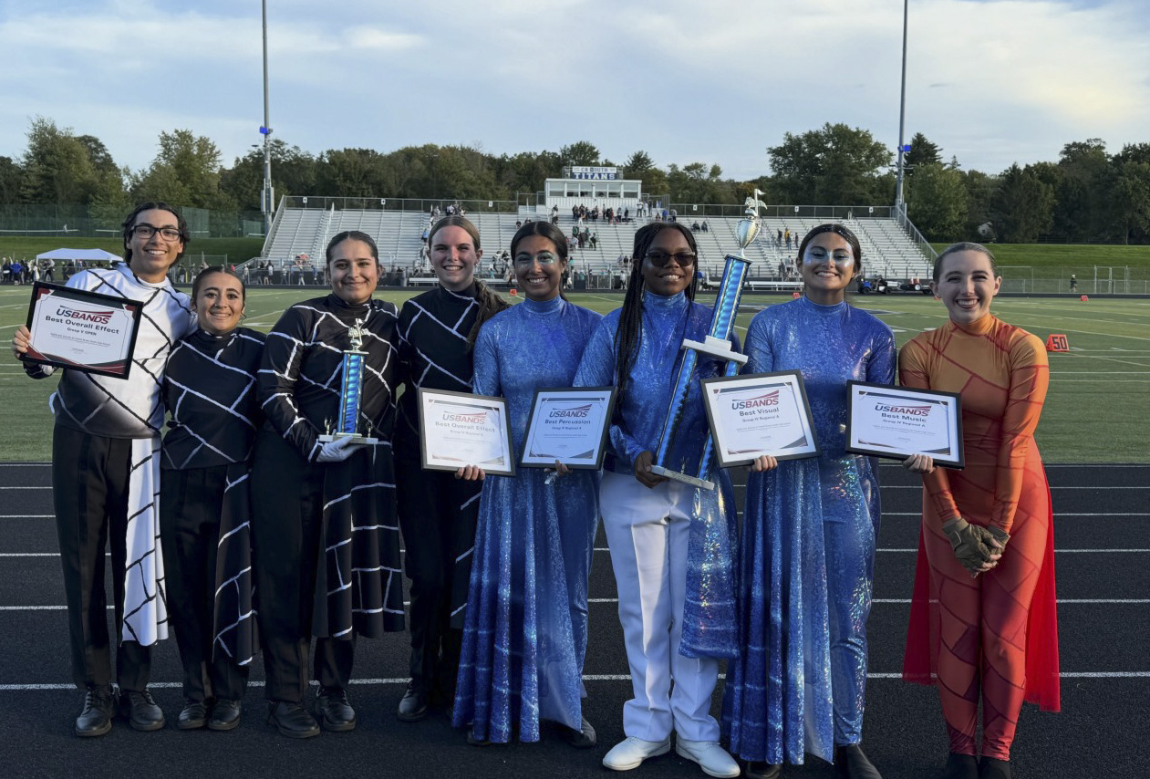 band students standing next to each other smiling with awards in their hands