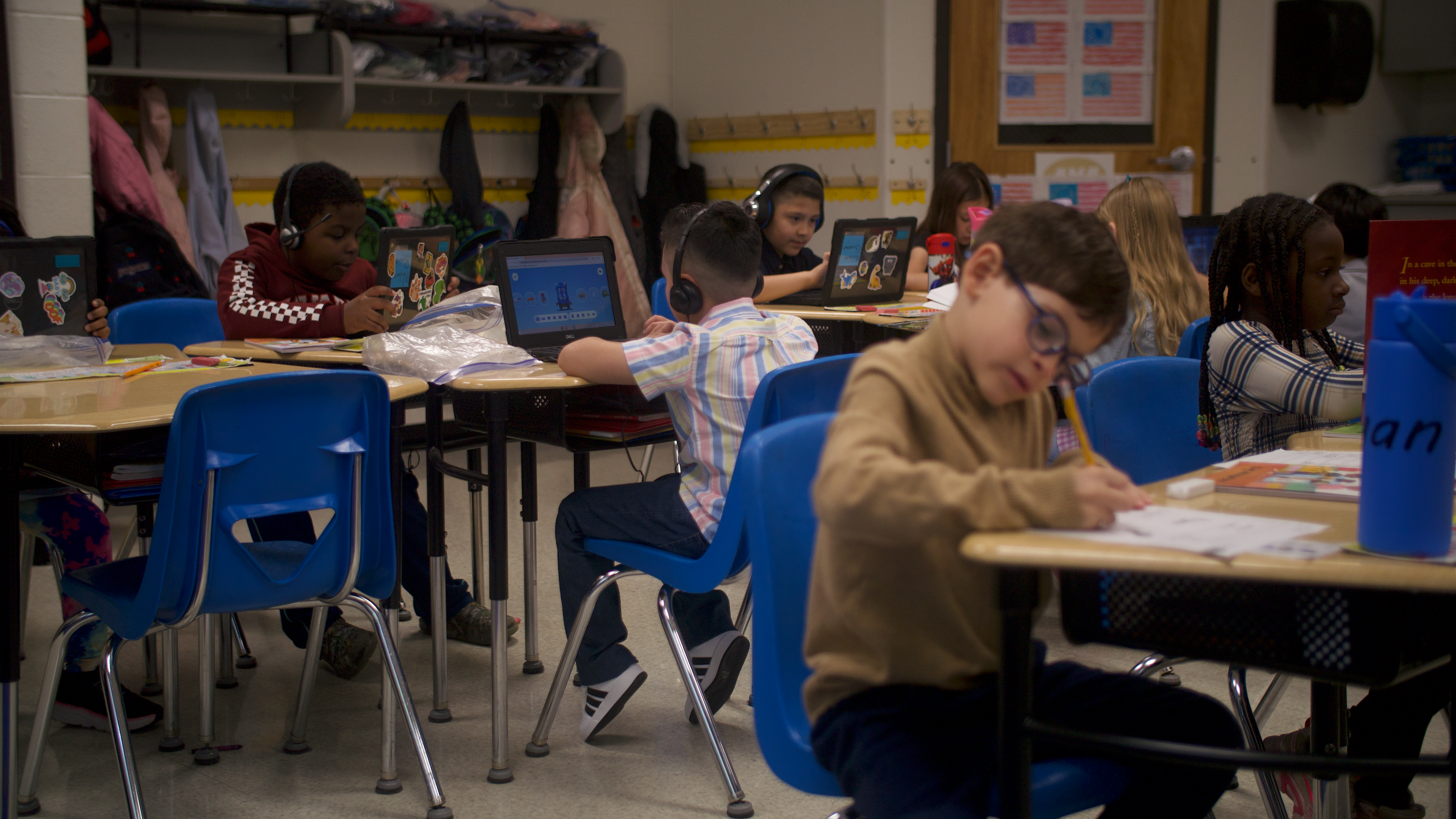 Students seated at their desks, actively engaged in a digital lesson on their Chromebook laptops.students seated at their desks, actively engaged in a digital lesson on their Chromebook laptops.