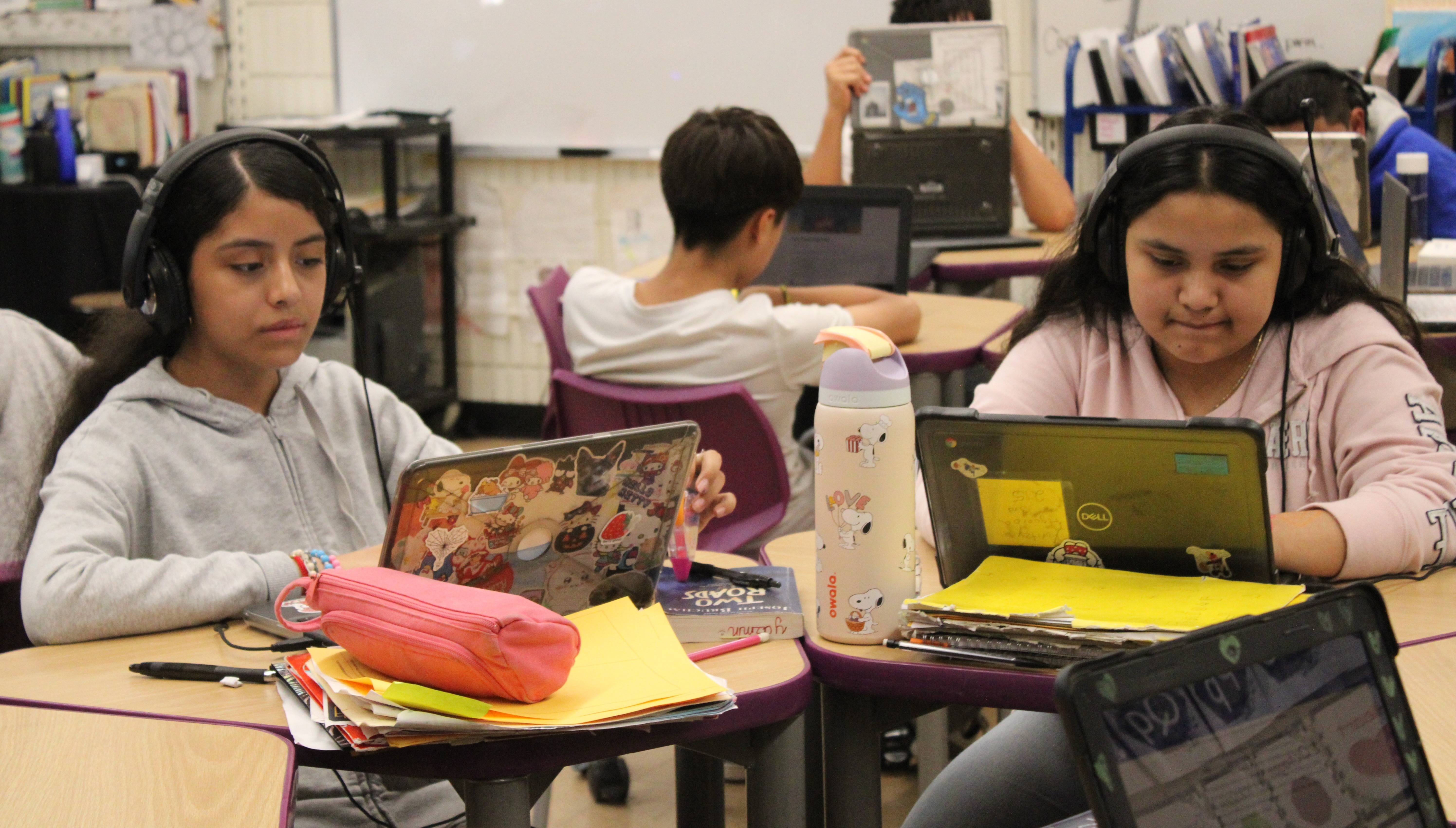 Students seated at their desks, actively engaged in a digital lesson on their Chromebook laptops.students seated at their desks, actively engaged in a digital lesson on their Chromebook laptops.
