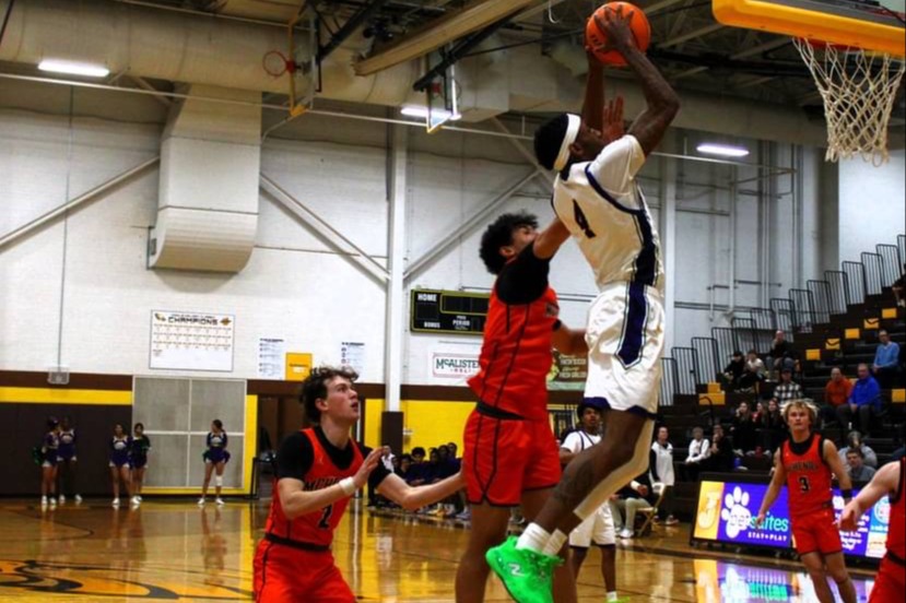 A high school basketball player mid-air, about to slam dunk the ball into the hoop.