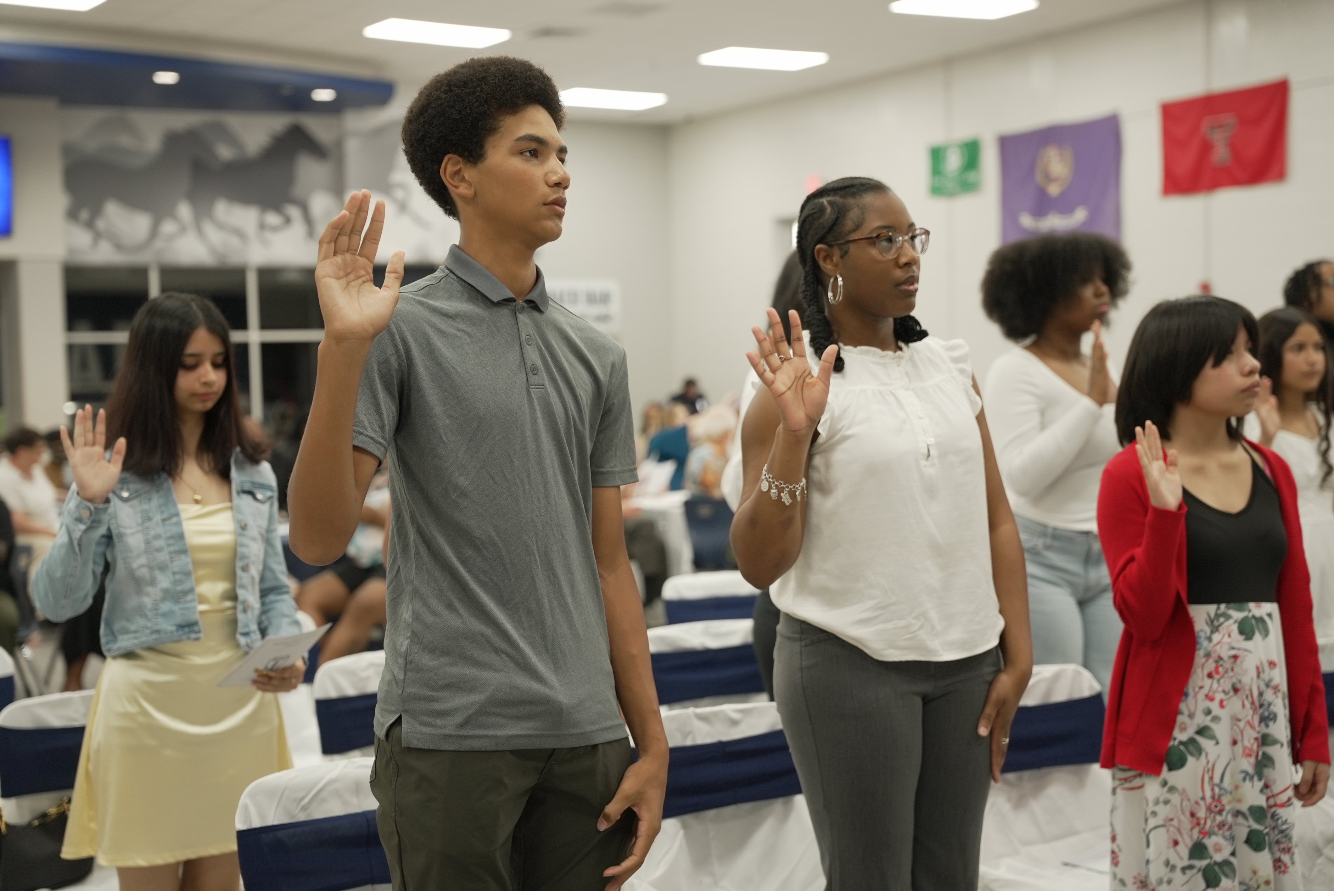 Students raising their hands to be inducted into the NHS