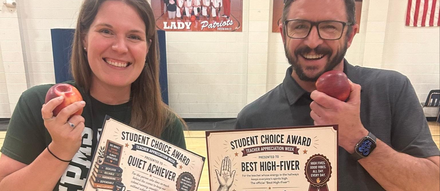 Ms. Crim and Mr. DeLando receive smile holding their student choice awards.