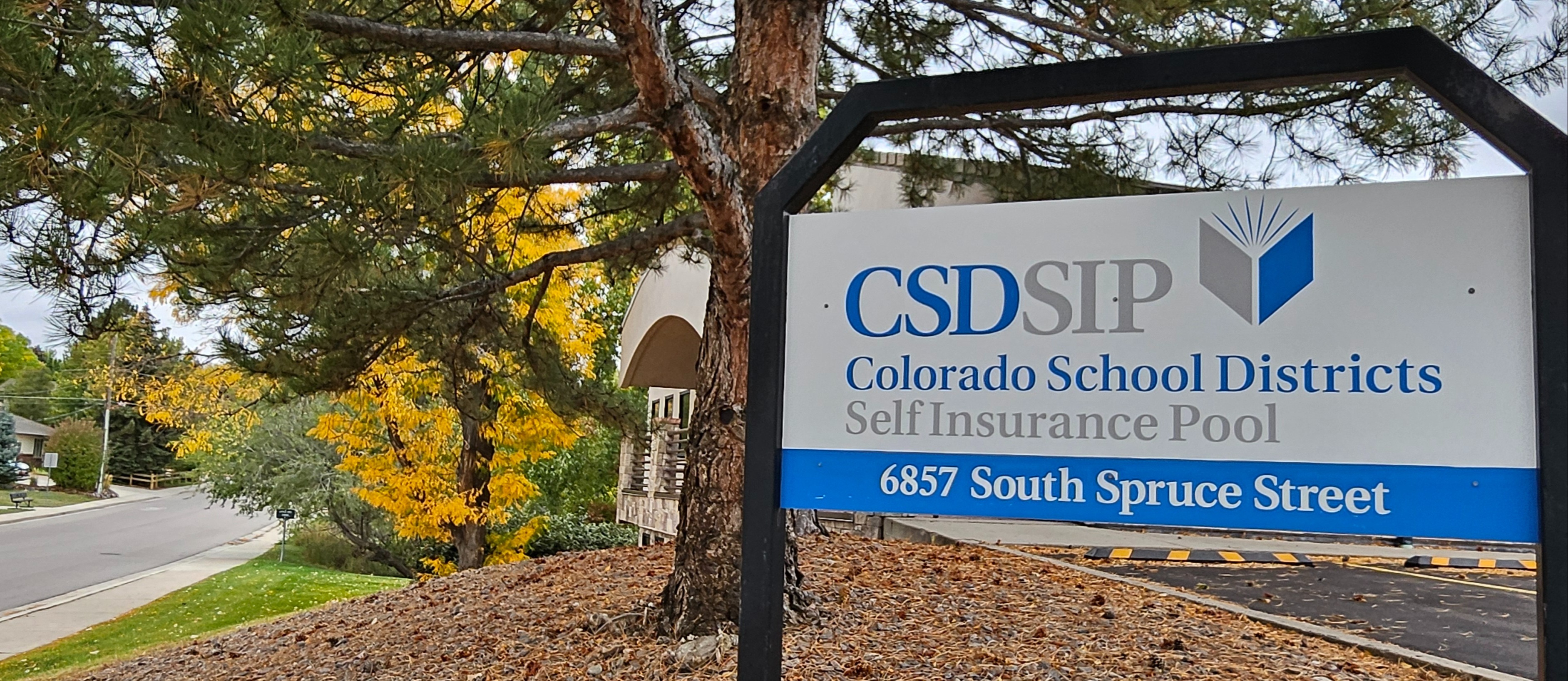organization sign with fall tree in the background