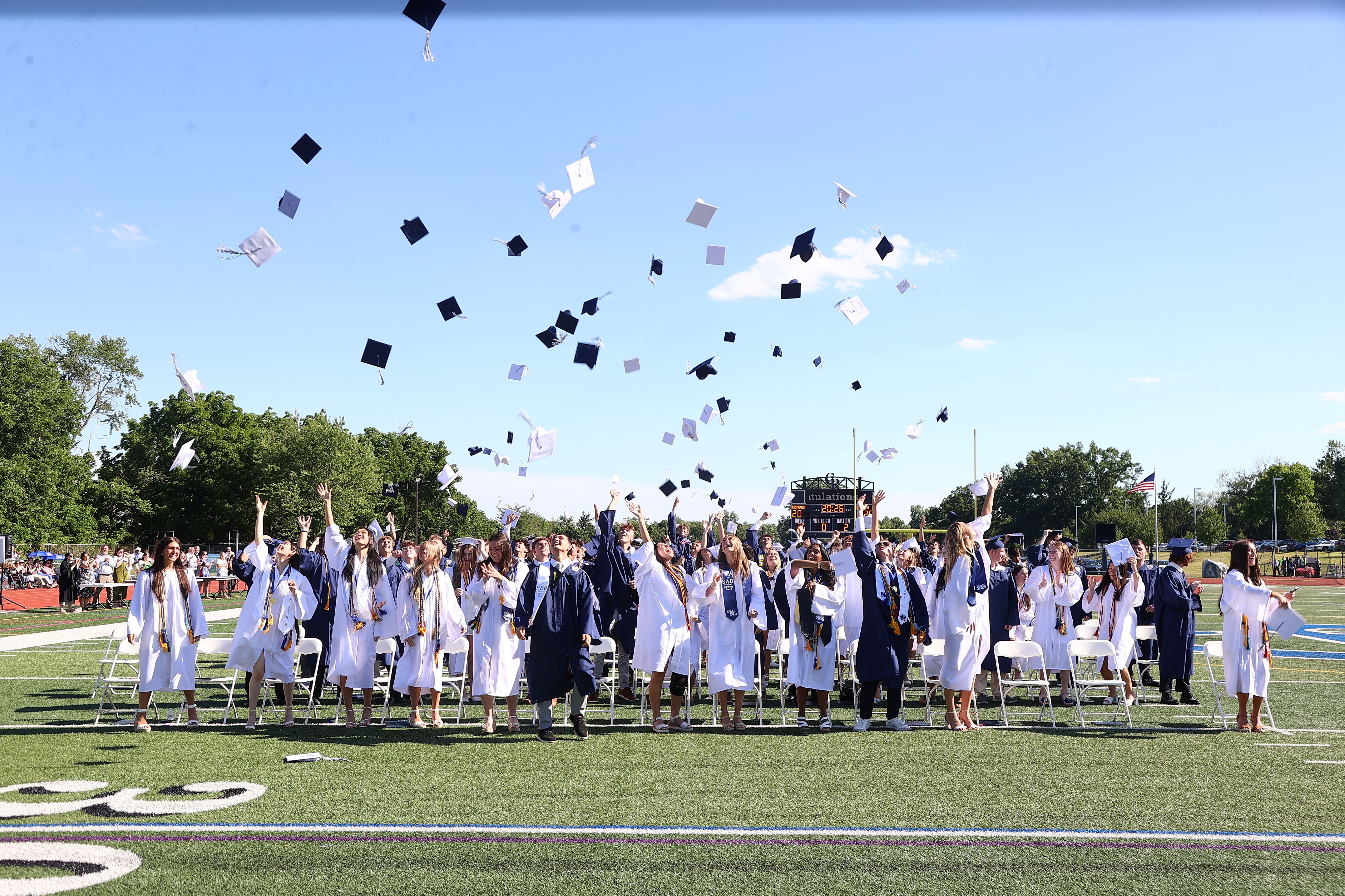 2026 graduates throwing their caps after graduating