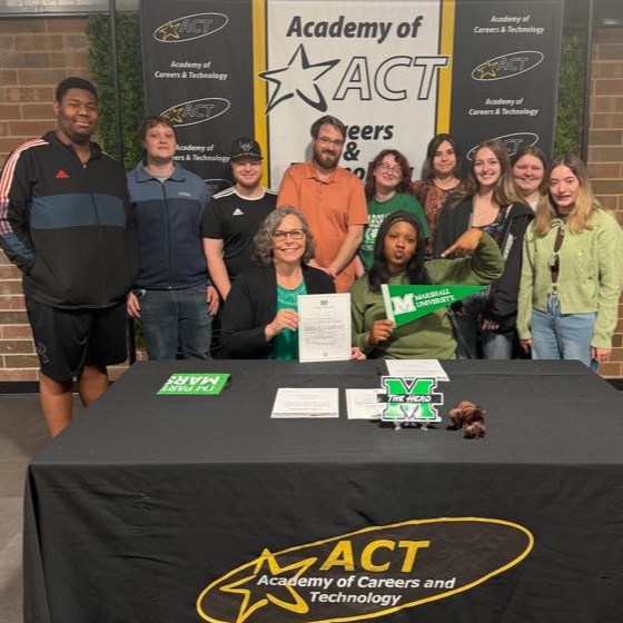 Academy of Careers and Technology student R'rhianna Holland celebrates signing her letter of intent to attend Marshall University with her ProStart Restaurant Management class and a college representative.