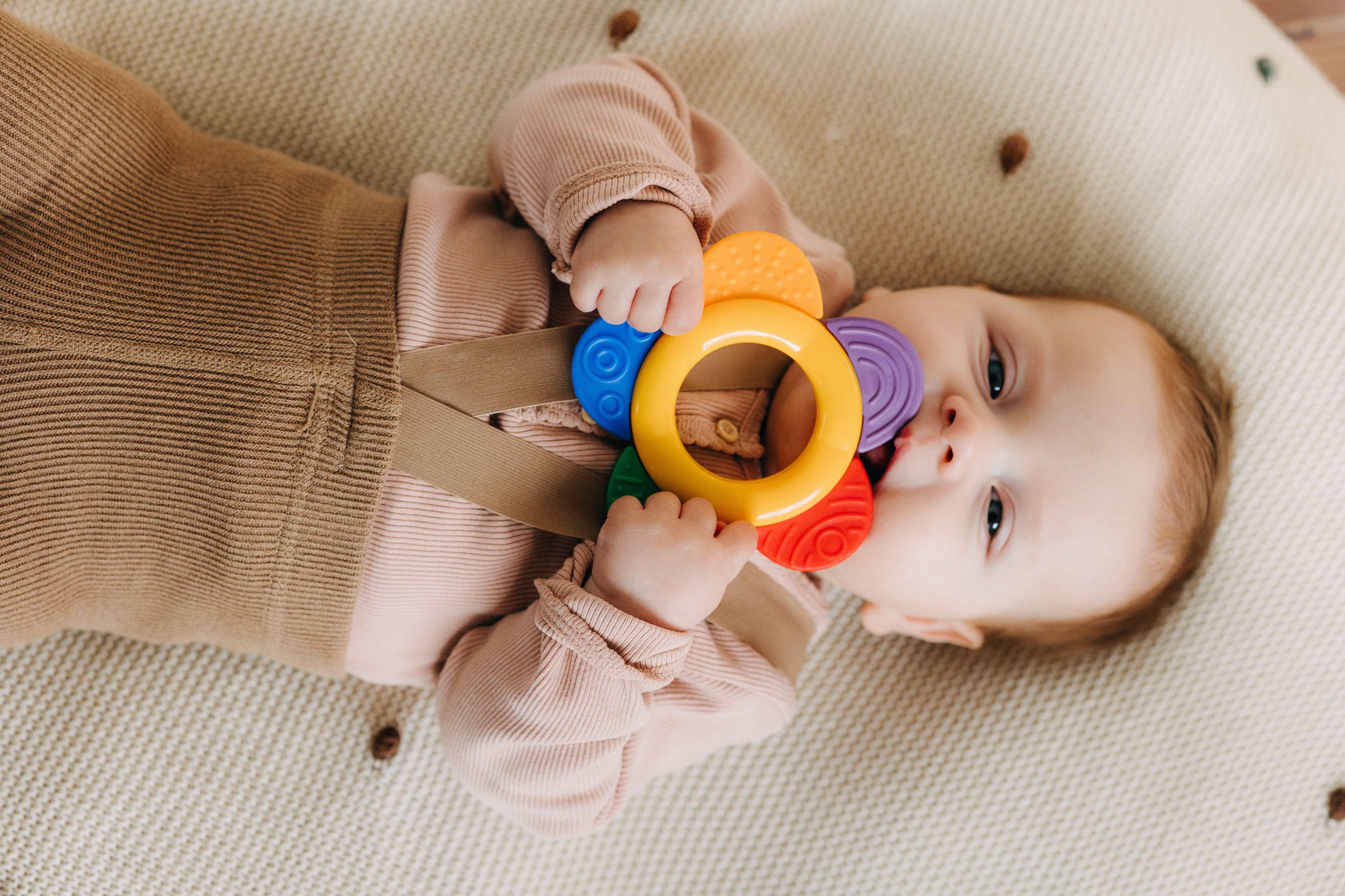 Baby laying with teething toy