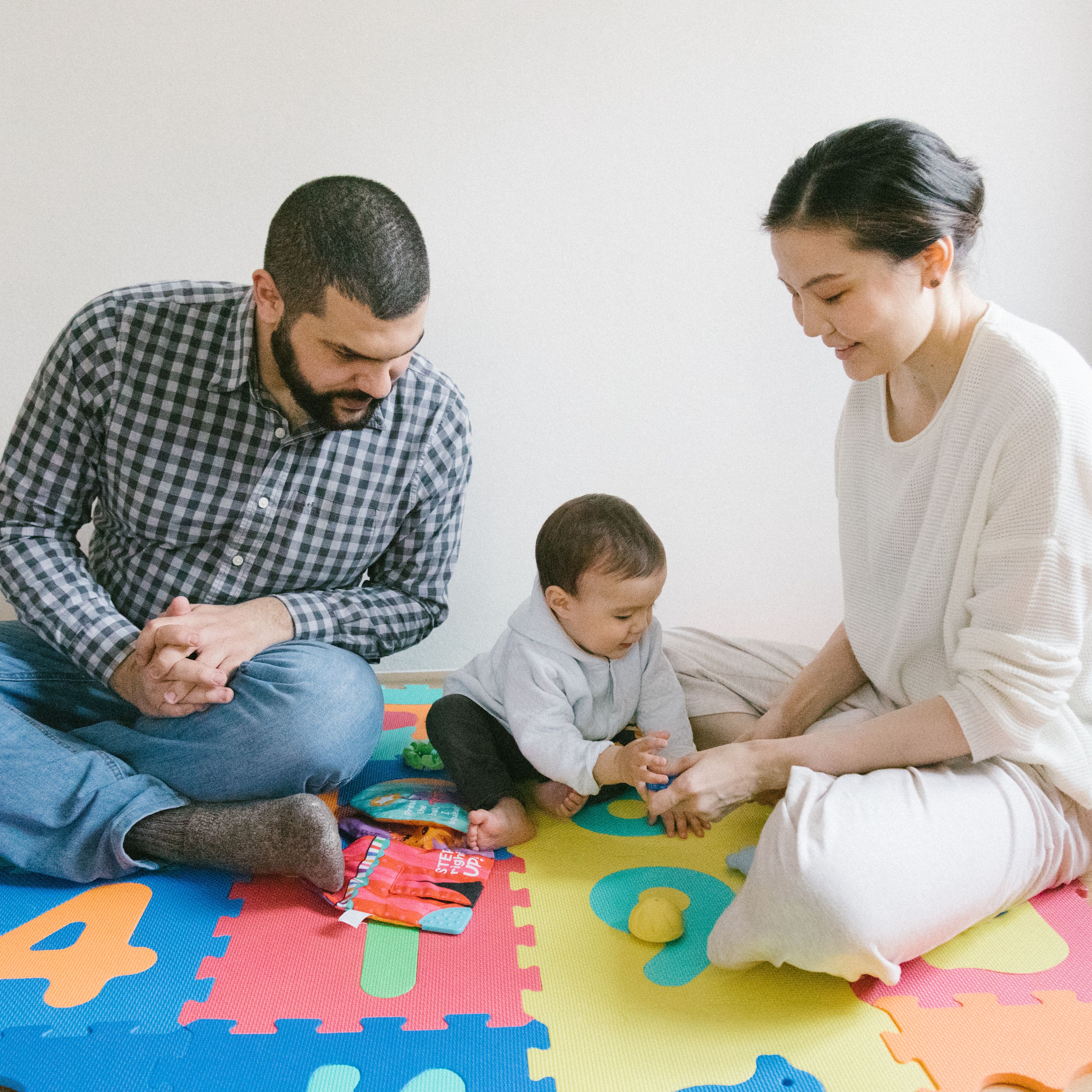 Parents playing with baby on the ground