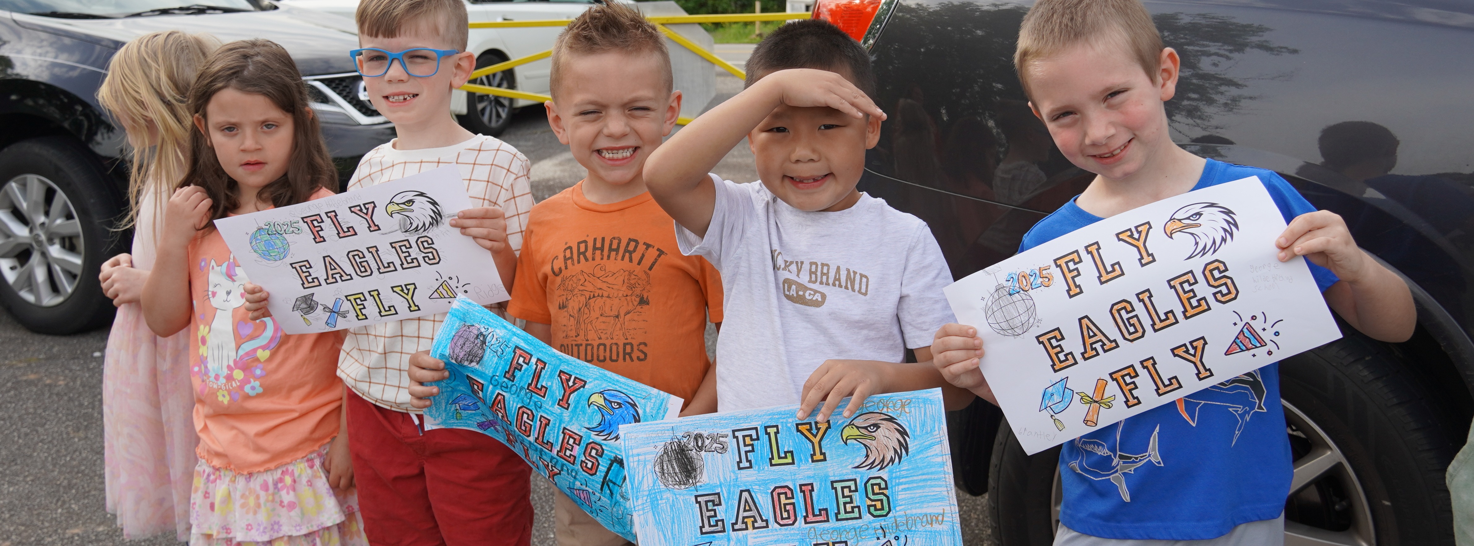 students holding signs that say fly eagles fly