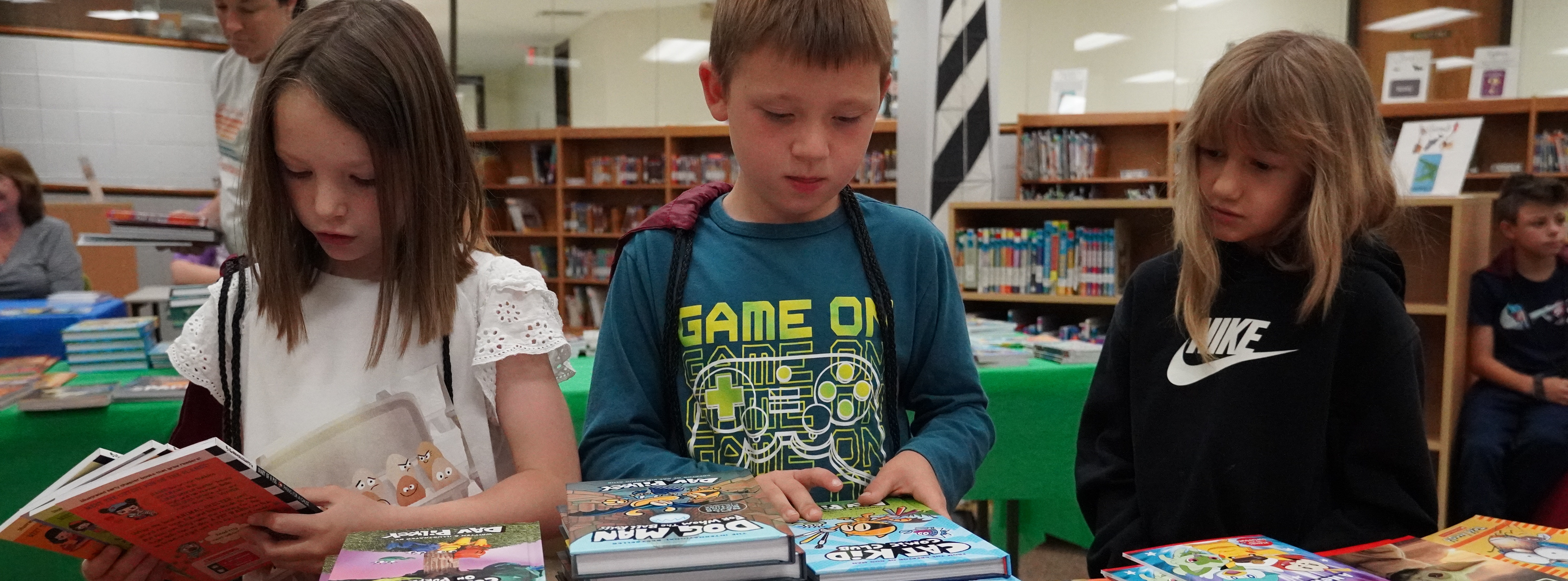 students looking at books on a table