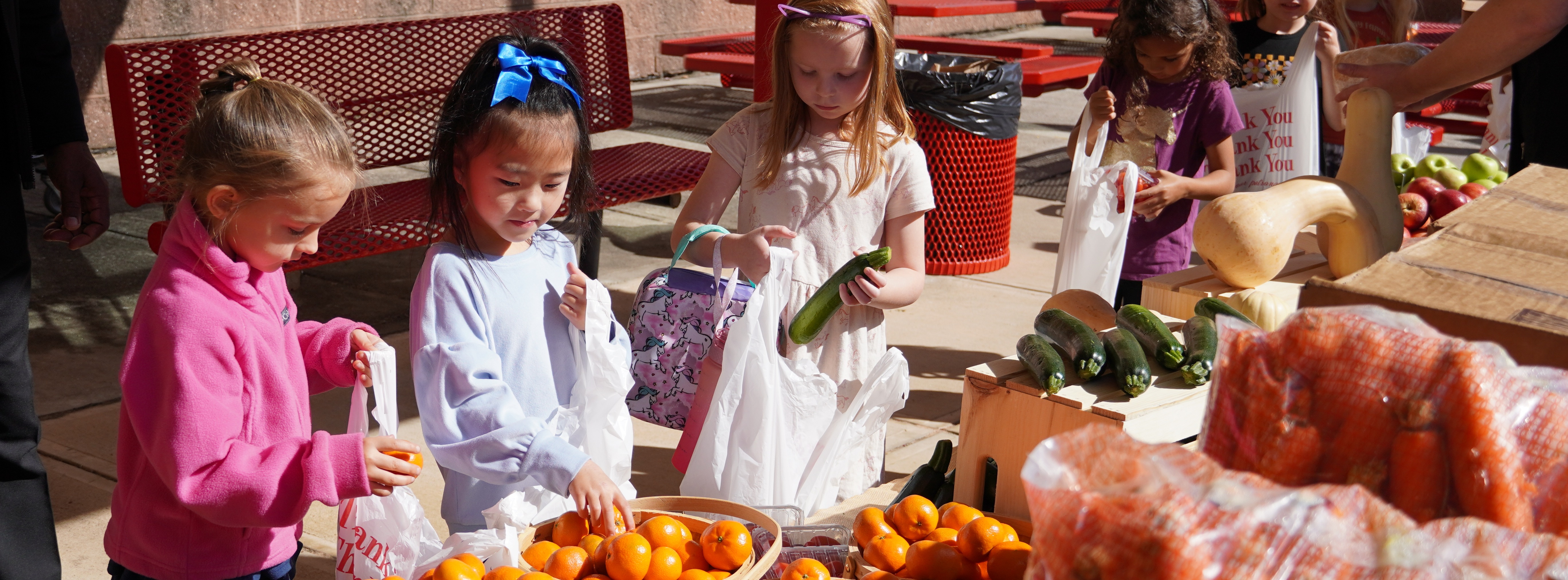 students in line getting produce from a table