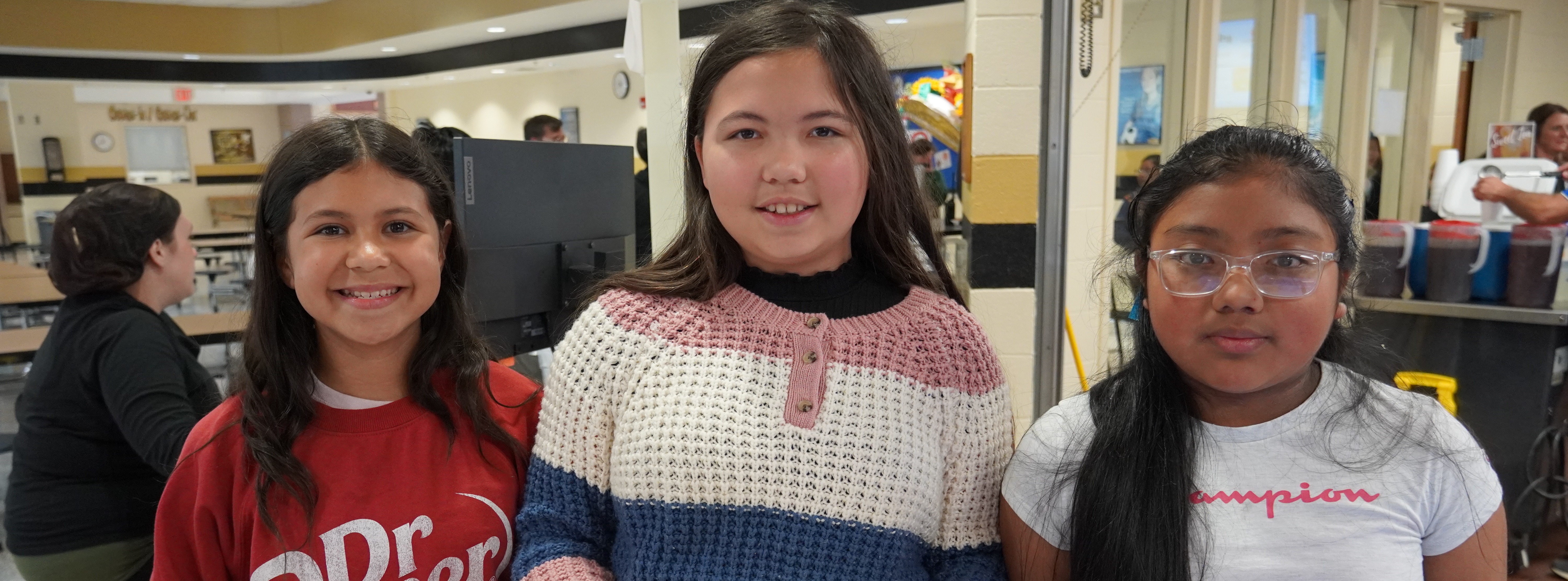 students in lunchroom with lunch trays
