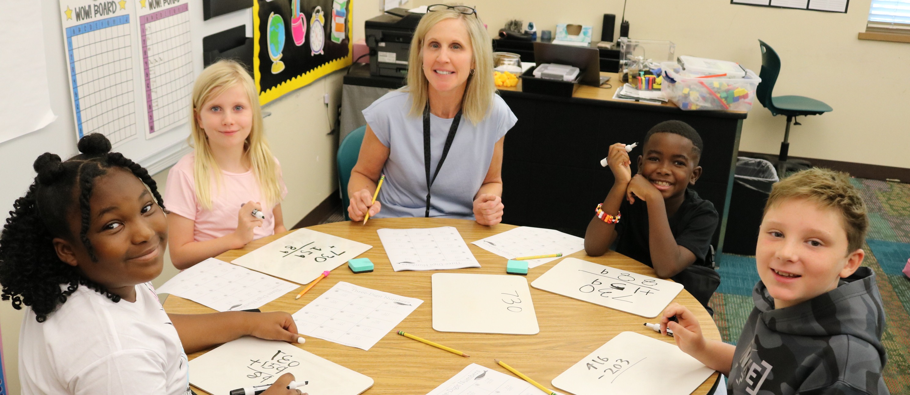 a teacher at a table with four students