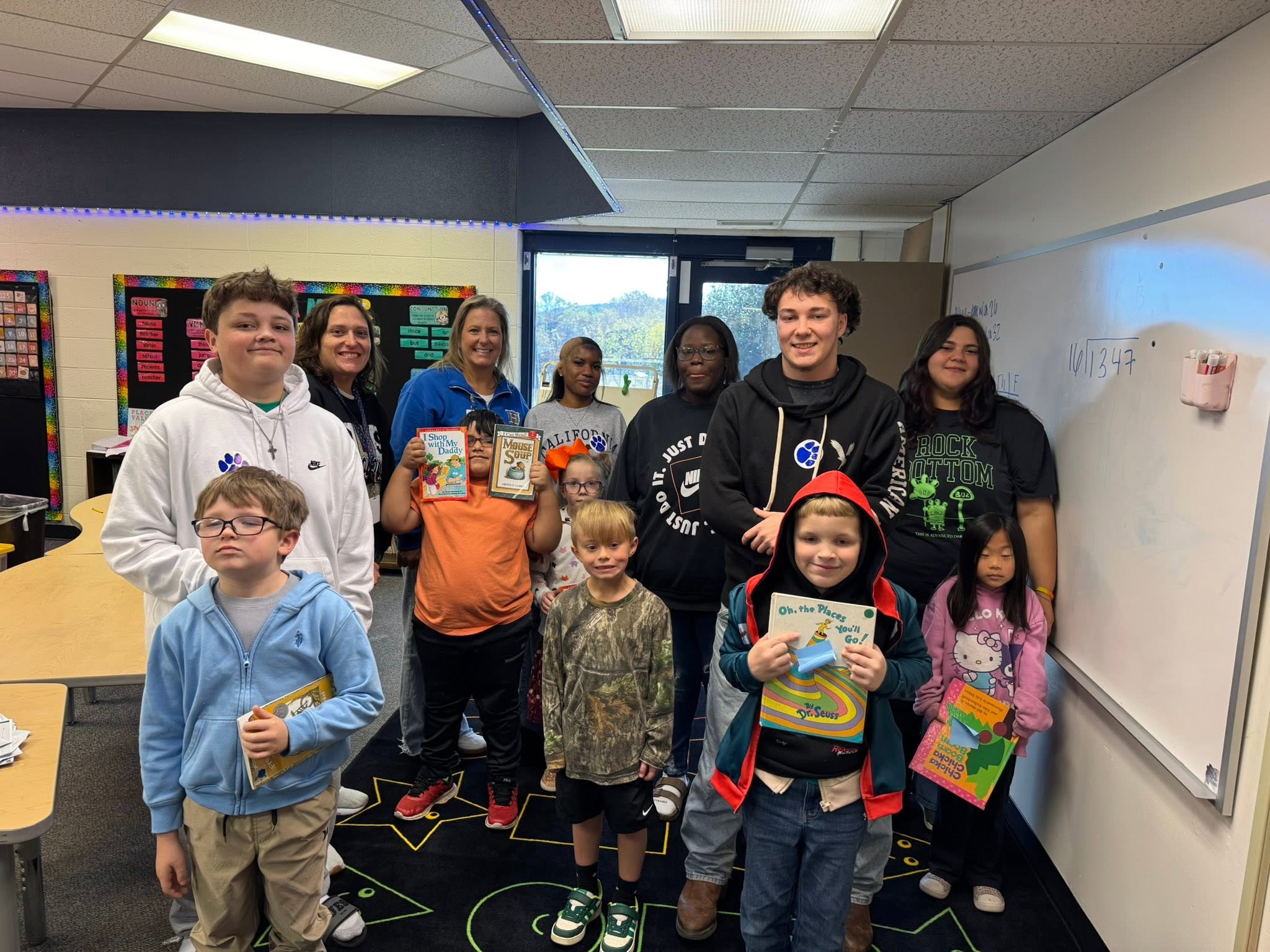 students standing in a classroom with books