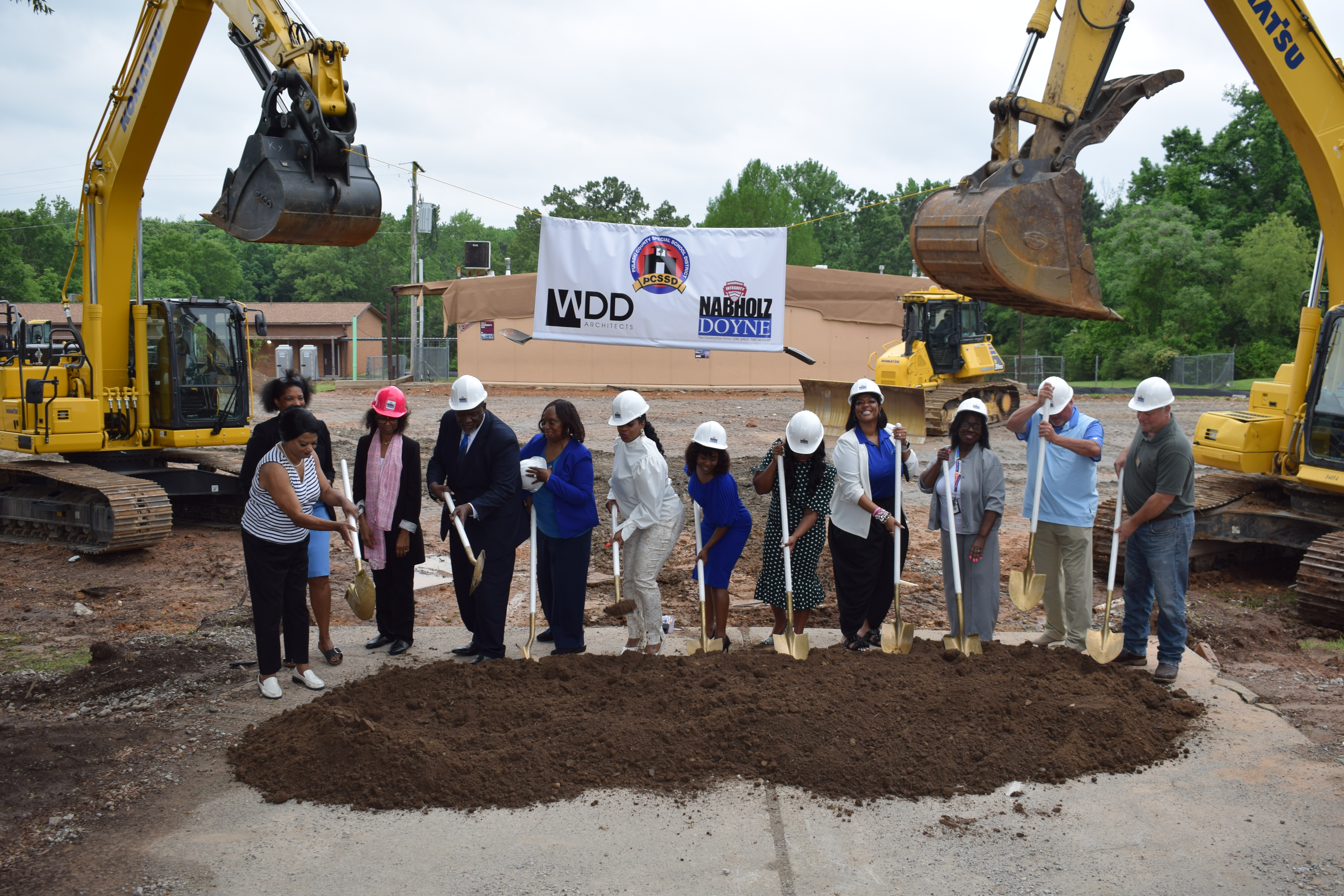 School administrators holding shovels prepare to turn the dirt at groundbreaking