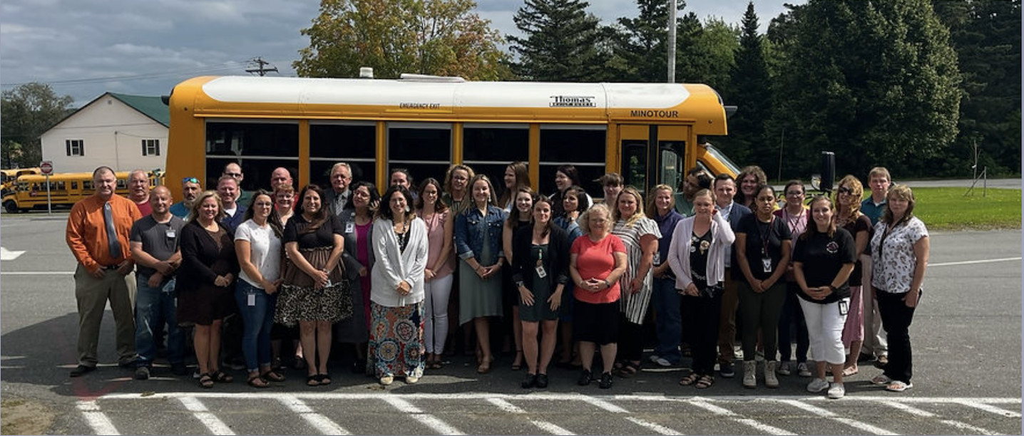 Staff in front of a bus