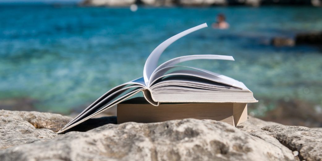 book on a beach, ocean in the background