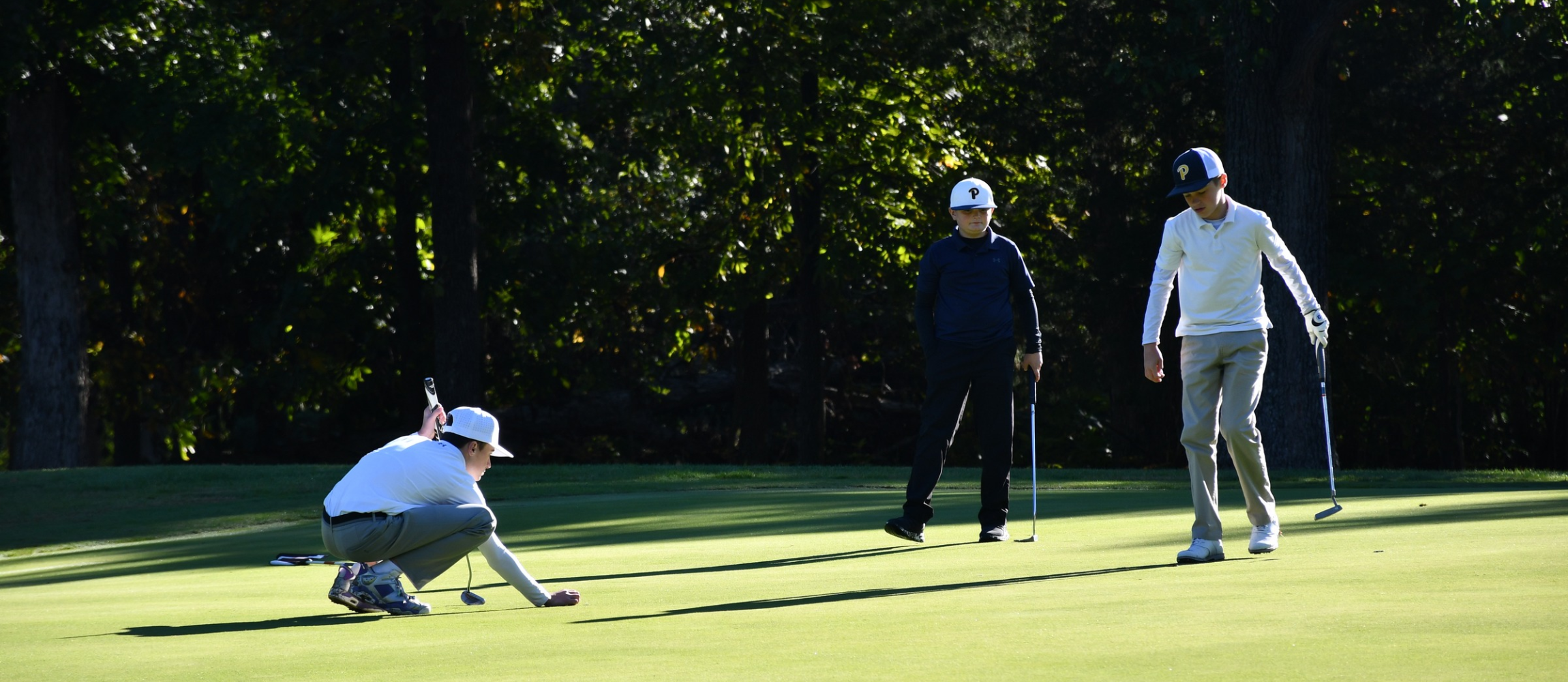 Three middle school golfers on golf course