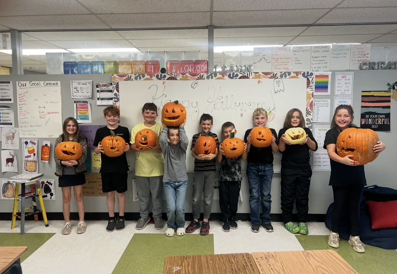 Group of students holding pumpkins