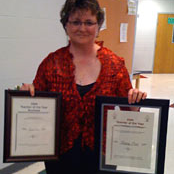 teacher holding two awards