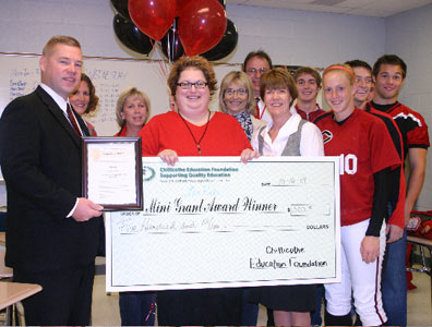 teachers and students holding big check