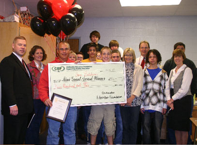 teachers and students holding big check