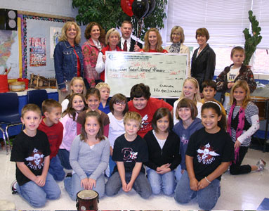 teachers and students holding big check