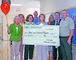 staff taking picture with big check