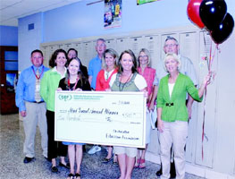 staff taking picture with big check