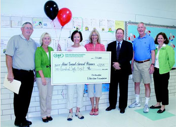 staff taking picture with big check