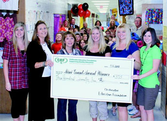 staff taking picture with big check