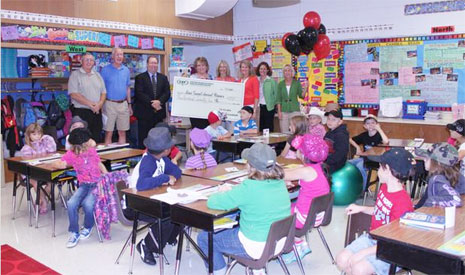 staff taking picture with big check