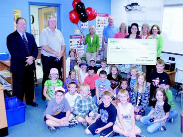 staff taking picture with big check