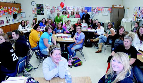 staff and students taking picture with big check