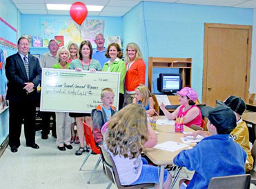 staff and students taking picture with big check