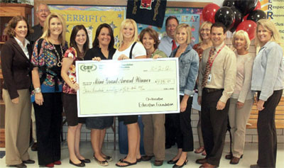 staff taking picture with big check