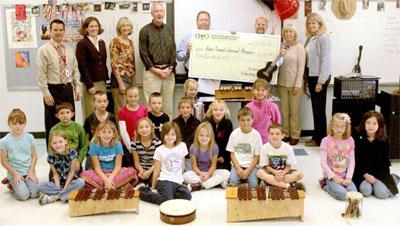 staff and students taking picture with big check