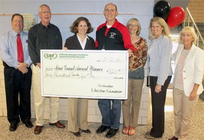 staff taking picture with big check