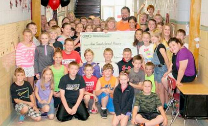 staff and students taking picture with big check