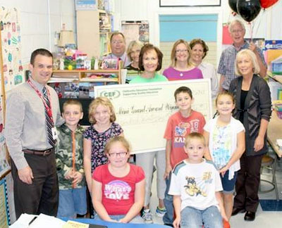 staff and students taking picture with big check