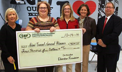 staff taking picture with big check