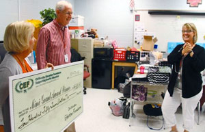 staff taking picture with big check