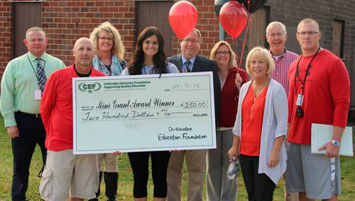 staff taking picture with big check