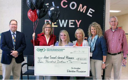 staff taking picture with big check