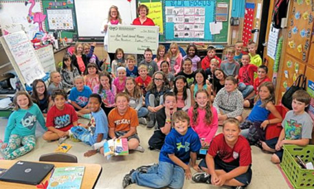 staff and students taking picture with big check