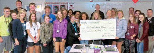 staff and students taking picture with big check