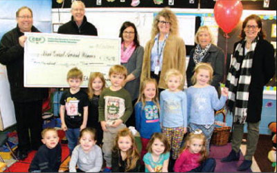 staff and students taking picture with big check