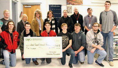 staff and students taking picture with big check