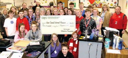 staff and students taking picture with big check